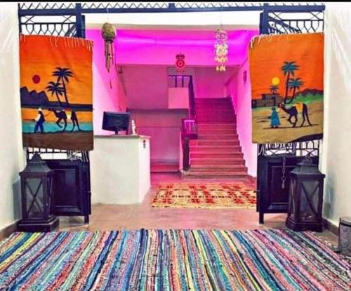 a pink room with a staircase with a painting on the wall at Dahab Vibes Hotel in Dahab