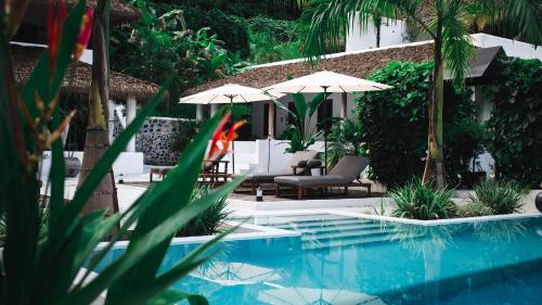 een zwembad met stoelen en parasols in een resort bij Vayu Retreat Villas in Coronado