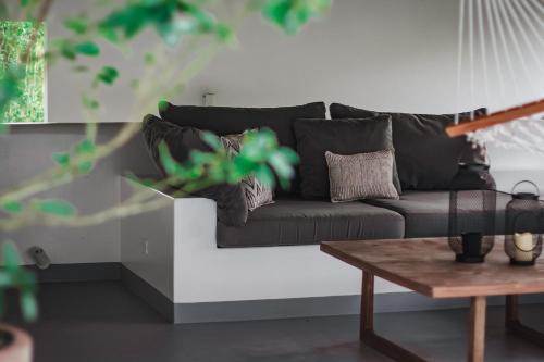 a black couch in a living room with a table at Vayu Retreat Villas in Coronado