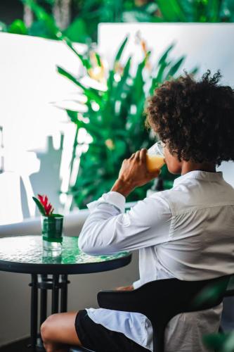 a man sitting at a table drinking a drink at Vayu Retreat Villas in Coronado