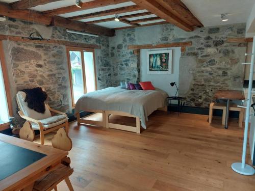 a bedroom with a bed in a room with stone walls at Revier im Bären-Quartier in Haslen