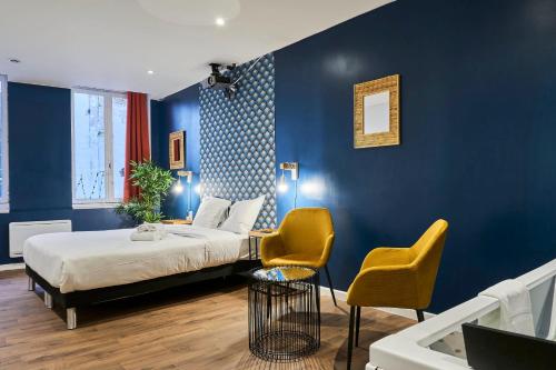 um quarto com uma cama e 2 cadeiras amarelas em NG SuiteHome - Lille I Roubaix Centre I Grand Place - Balnéo - Netflix - Wifi em Roubaix
