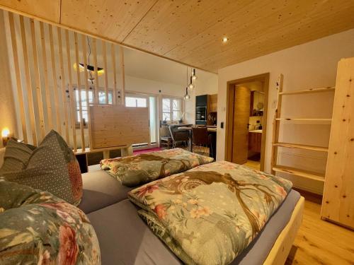a bedroom with two beds and a living room at Bäumers Retreat - Das Aktiv- & Regenerationsjuwel in Bad Hindelang