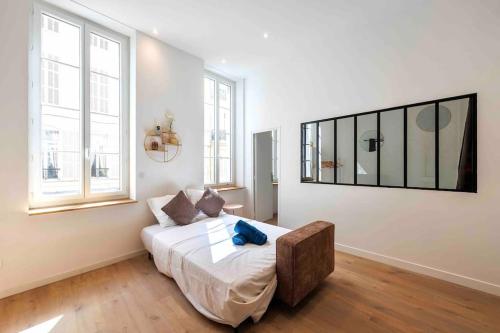 een slaapkamer met een bed in een kamer met ramen bij VIEUX PORT, FÉRREOL 6ème, appartement 8 personnes in Marseille