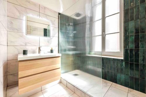une salle de bain avec un lavabo et un miroir dans l'établissement VIEUX PORT, FÉRREOL 6ème, appartement 8 personnes, à Marseille