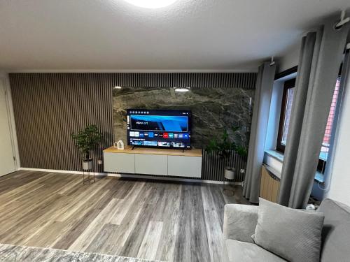 een woonkamer met een grote tv en een aquarium bij Suite 2 SZ- Lichtenberg in Salzgitter