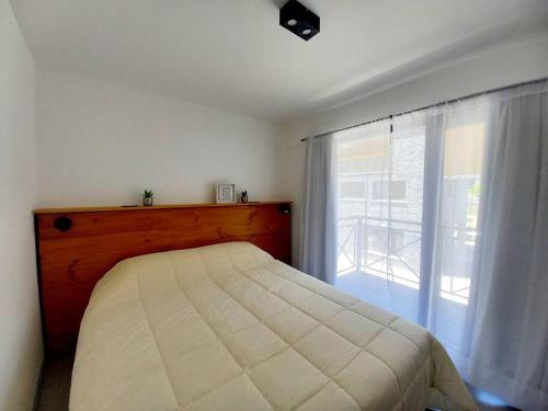 sypialnia z łóżkiem i dużym oknem w obiekcie Joli Apartments - Studio B - 2 pax en el corazón de la ciudad w mieście San Martín de los Andes