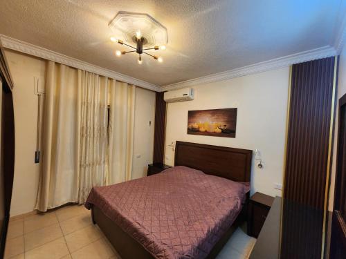a bedroom with a bed and a ceiling fan at Shafa Badran apt in Amman