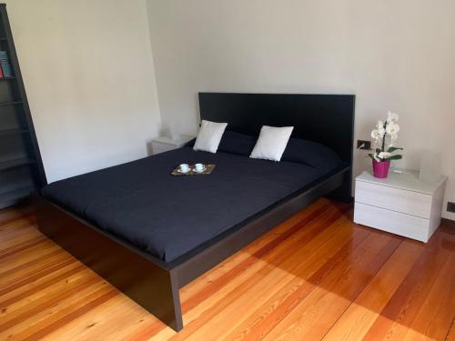 a bed in a room with a black bed frame at Casa Dilma in Lenno