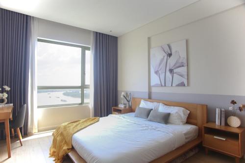 een slaapkamer met een bed, een bureau en een raam bij €•€• Lux Riverview 2brs #diamondisland in Ho Chi Minh-stad