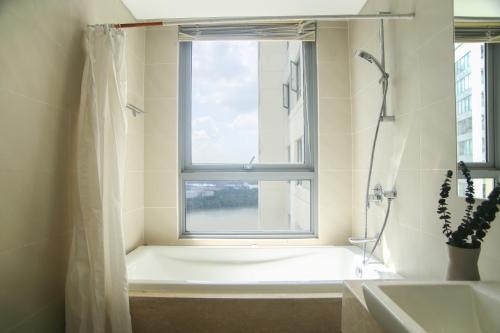 een badkamer met een bad en een raam bij €•€• Lux Riverview 2brs #diamondisland in Ho Chi Minh-stad