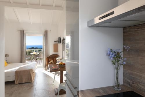 - une chambre avec un lit et un vase de fleurs dans l'établissement Costa Marina, à Porto-Vecchio