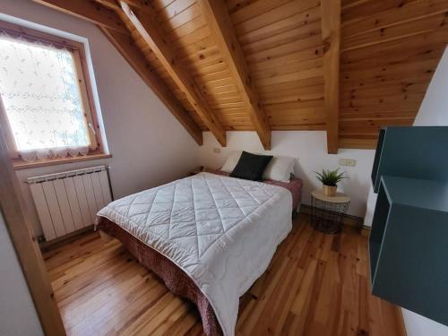 - une chambre avec un lit dans une pièce dotée de plafonds en bois dans l'établissement Duplex en la Vall de Boí, plena naturaza, à Bohí