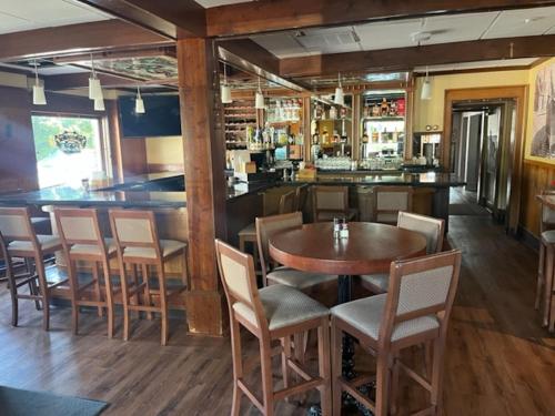 a bar with a wooden table and chairs at The Port Hotel in Port Washington