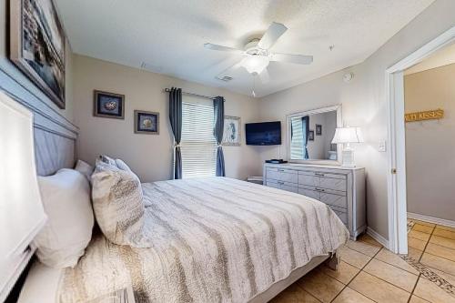een slaapkamer met een bed en een plafondventilator bij Grand Beach Resort in Gulf Shores