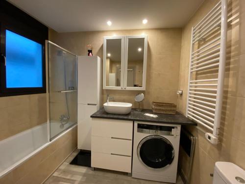 uma casa de banho com uma máquina de lavar roupa e um lavatório em Orquidia El Tarter em El Tarter