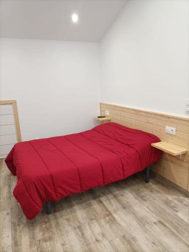 a bedroom with a red bed with a wooden desk at Jacuzzi Barcala in Valga