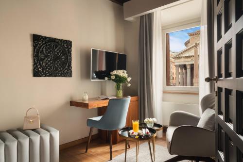 una camera d'albergo con tavolo, sedie e finestra di Antico Albergo del Sole al Pantheon a Roma