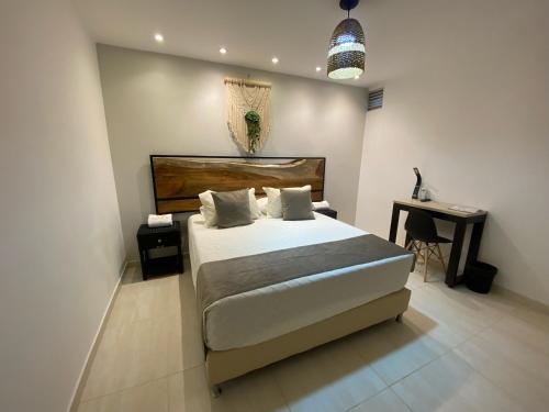 a bedroom with a large bed and a desk at Maidy Luxury Hotel in Medellín