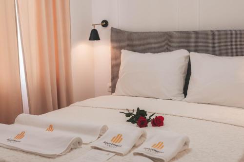 a bed with two towels and two roses on it at Luxury Jacuzzi Apartment in Mostar