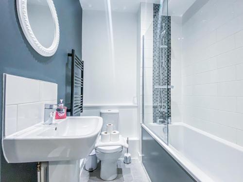 La salle de bains est pourvue d'un lavabo, de toilettes et d'une baignoire. dans l'établissement Cathedral View Apartments by Elegance Living, à Peterborough