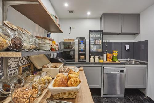 a kitchen with a counter with bread and pastries on it at Huni Hôtel in Paris