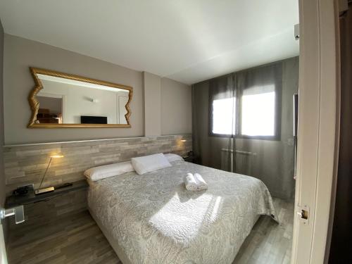 um quarto com uma cama com um espelho na parede em Orquidia El Tarter em El Tarter
