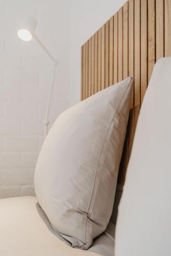 a pillow on a bed with a wooden headboard at Design Holiday Home in Ermelo
