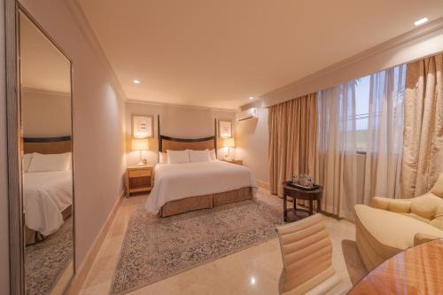a hotel room with a bed and a living room at Hotel Santa Anita a Balderrama Hotel Collection in Los Mochis