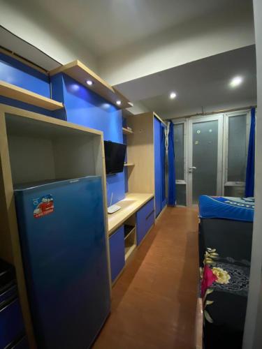 Habitación con paredes azules, escritorio y cama. en K&G homestay, en Bandung