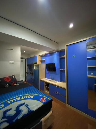 a bedroom with blue cabinets and a bed and a desk at K&G homestay in Bandung