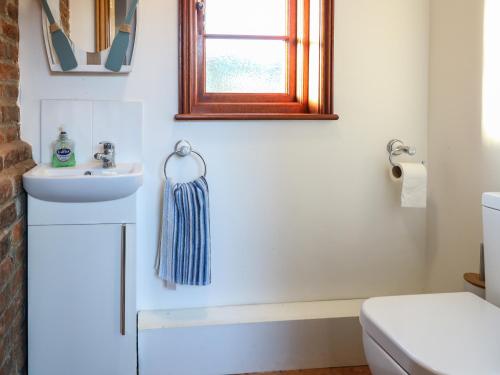 y baño con lavabo y aseo. en Lanthorn Cottage en Norwich