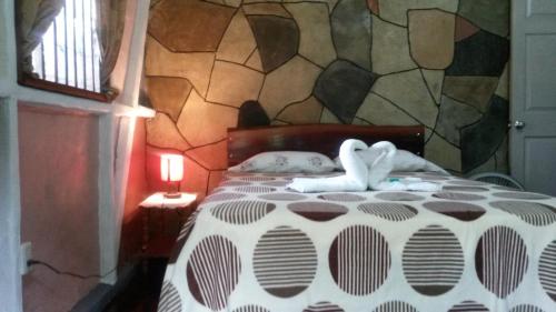 a bedroom with a bed with two towels on it at Nacientes Lodge in Bijagua