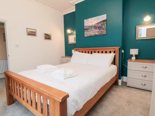 ein Schlafzimmer mit einem Bett und einer grünen Wand in der Unterkunft The Old Police House in Saltburn-by-the-Sea