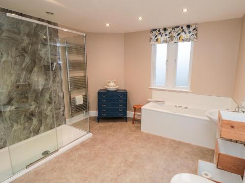 Das Bad ist mit einer Badewanne und einer Glasdusche ausgestattet. in der Unterkunft The Old Police House in Saltburn-by-the-Sea