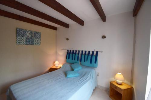 una camera con un letto blu e due lampade di Agréable maison de ville a Agen