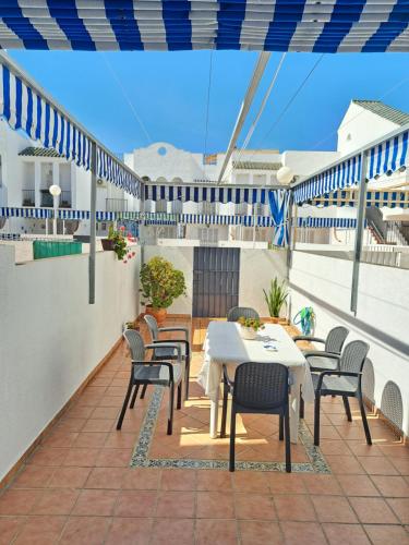 un patio con mesas y sillas en el balcón en Dúplex 4, primera línea de Playa, en Sanlúcar de Barrameda