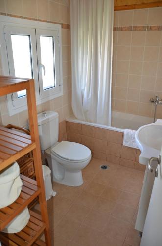 a bathroom with a toilet and a tub and a sink at L'Olivetta in Lithakia