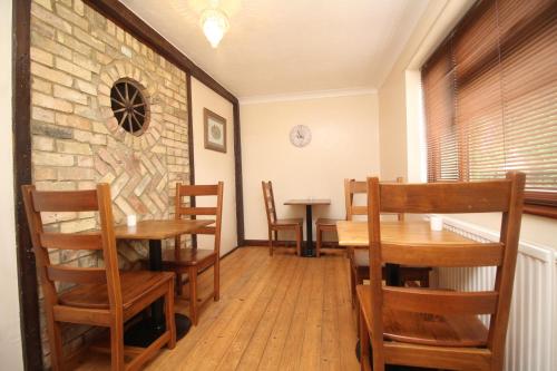 a dining room with wooden tables and chairs at Highfields Holidays bed & breakfast in Peterborough