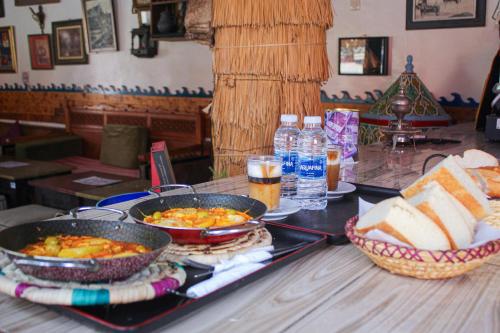 una mesa cubierta con dos sartenes de comida y pan en Happy Home Dream Surf, en Imsouane