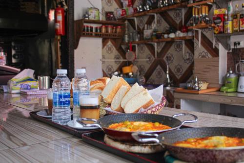 a table with two pans of food and bread and drinks at Happy Home Dream Surf in Imsouane