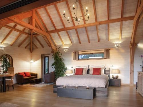 a bedroom with a large bed and a wooden ceiling at Cabane de Prestige avec Jacuzzi et Sauna privatifs in Alzonne