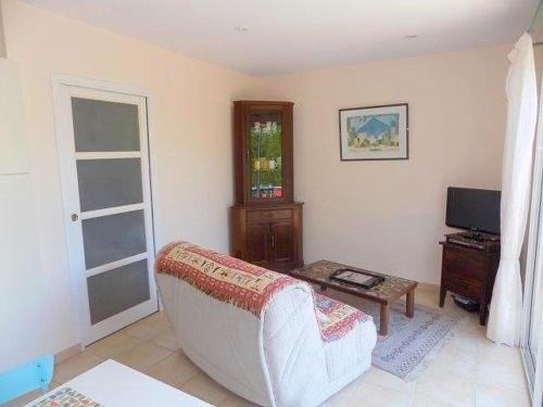 a living room with a white couch and a tv at Saint Palais sur Mer - PETITE MAISON - dans un CADRE PRIVILIGIÉ au CALME in Saint-Palais-sur-Mer