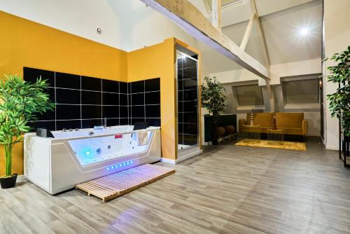 un salón con bañera en una sala con paredes amarillas en NG SuiteHome - Lille I Roubaix Centre I Grand Place - Balnéo - Netflix - Wifi, en Roubaix