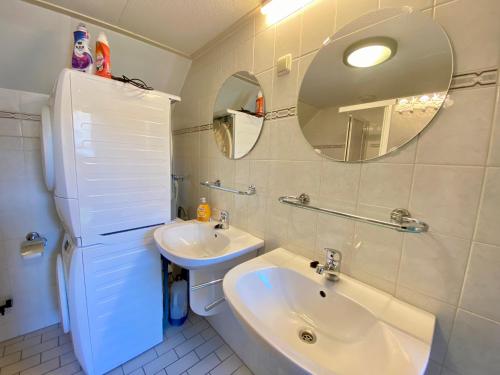 ein weißes Badezimmer mit einem Waschbecken und einem Spiegel in der Unterkunft Ooghduyne 271 in Julianadorp