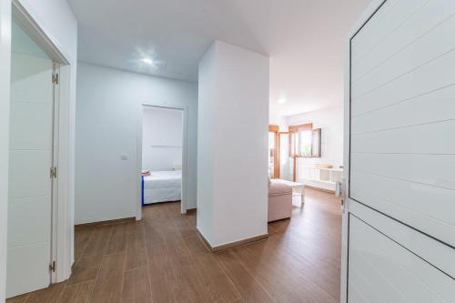 una camera con corridoio, letto e specchio di Apartamento BORA a Morro del Jable