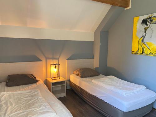 ein Schlafzimmer mit 2 Betten und einer Lampe in der Unterkunft Ooghduyne 271 in Julianadorp