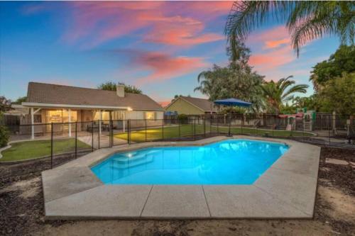 a swimming pool in front of a house at Revitalizing 3 Bedroom Home With Pool, Pet-Friendly, Wi-fi in Bakersfield