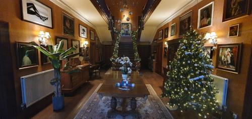 una sala de estar con un árbol de Navidad y una escalera en The Apartment at Pen Y Coed Hall en Dolgellau