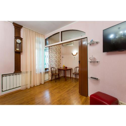 a living room with a television and a table at Naykova district Apartments in Kharkiv